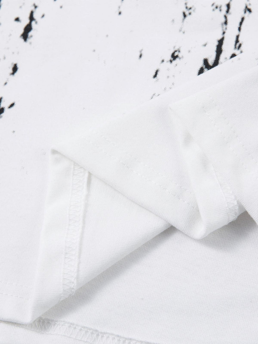 Intricate look at TALISHKO's retro T-shirt, showcasing white fabric with unique black patterns.