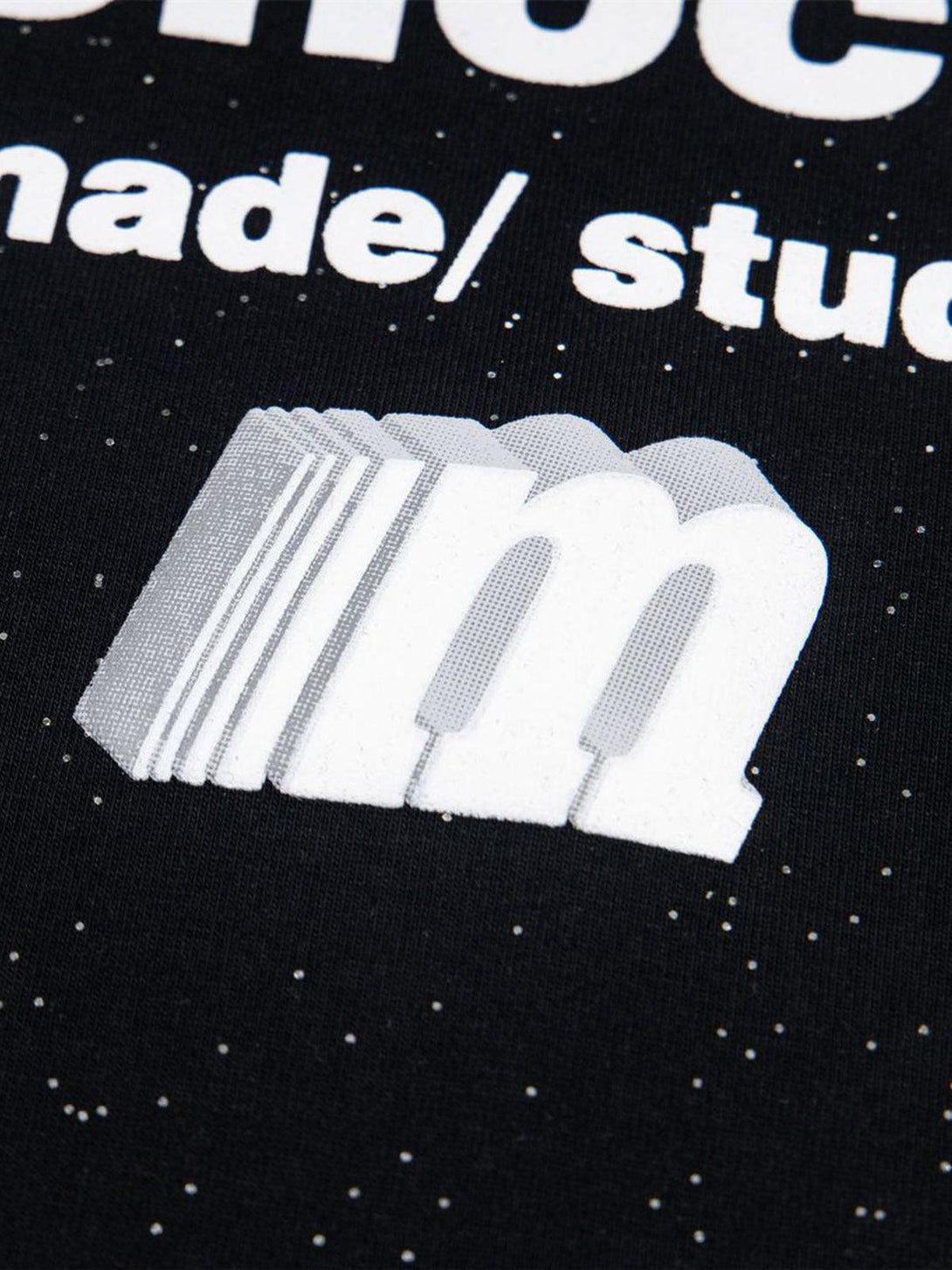 Zoomed-in view of TALISHKO's starry sky print and bold font on a black short-sleeved T-shirt.