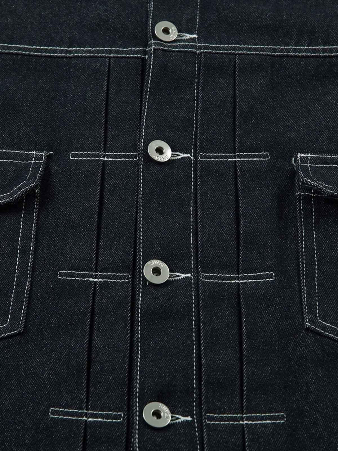 Detailed fabric and stitching on TALISHKO's denim jacket, highlighting retro design elements.