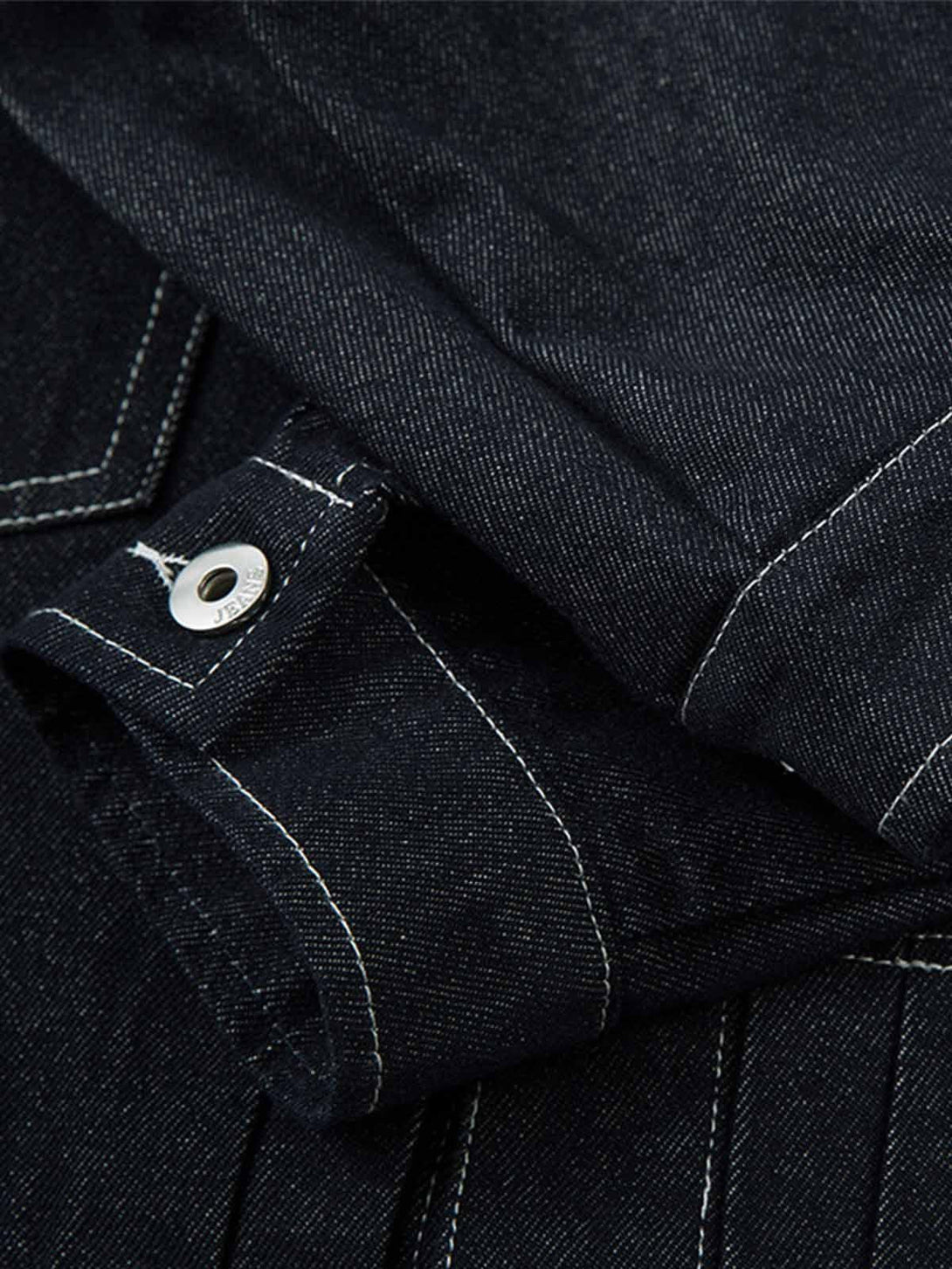 Intricate look at TALISHKO's denim jacket sleeve, highlighting the retro contrast stitching.