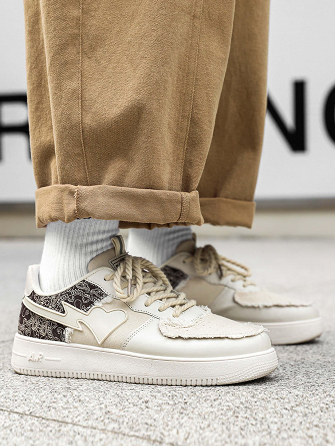 TALISHKO low-top skate shoes in a beige tone with unique pattern details, paired with rolled-up pants.