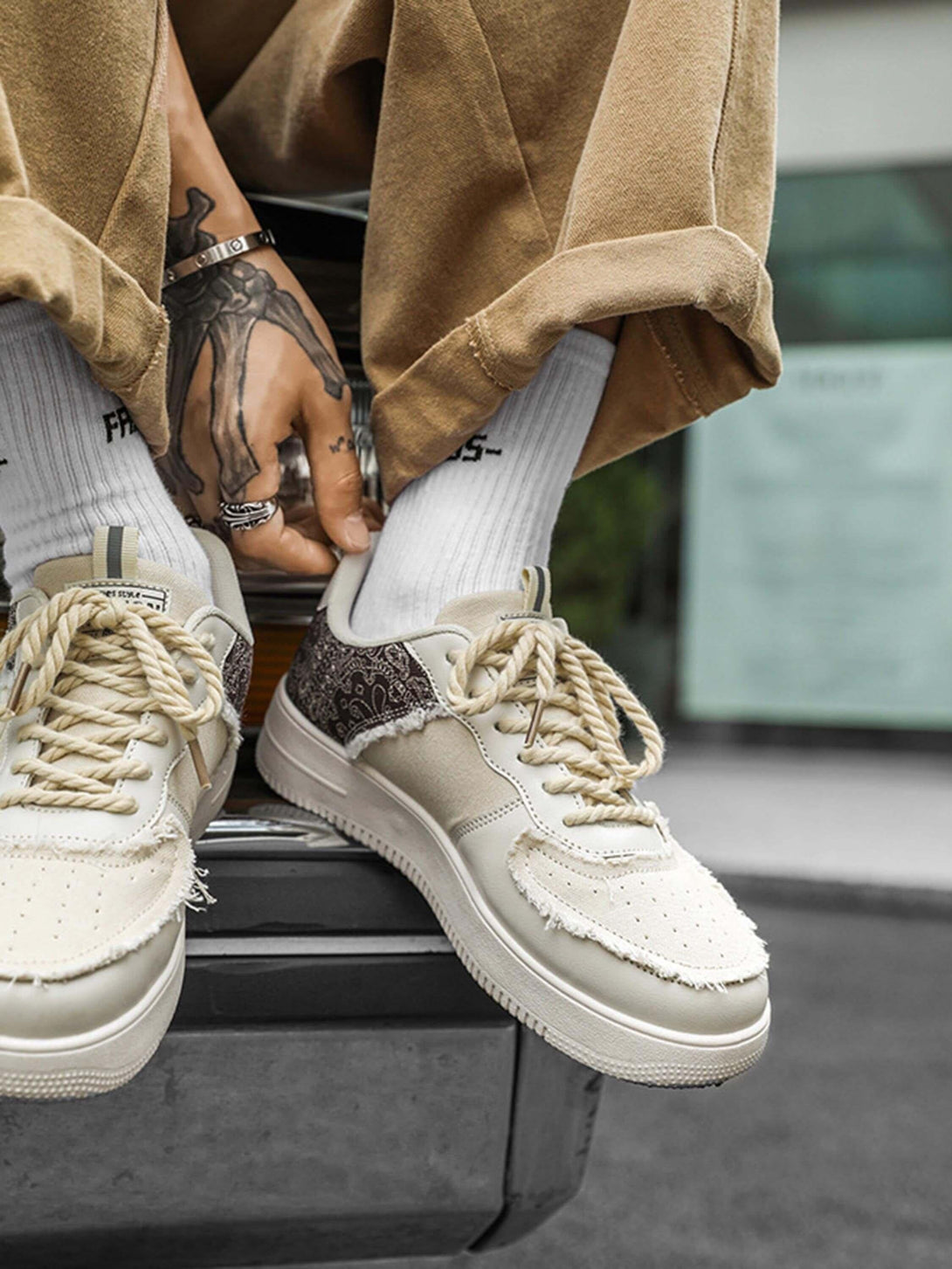 TALISHKO men's skate shoes in beige with frayed details, styled with cuffed pants and white socks.