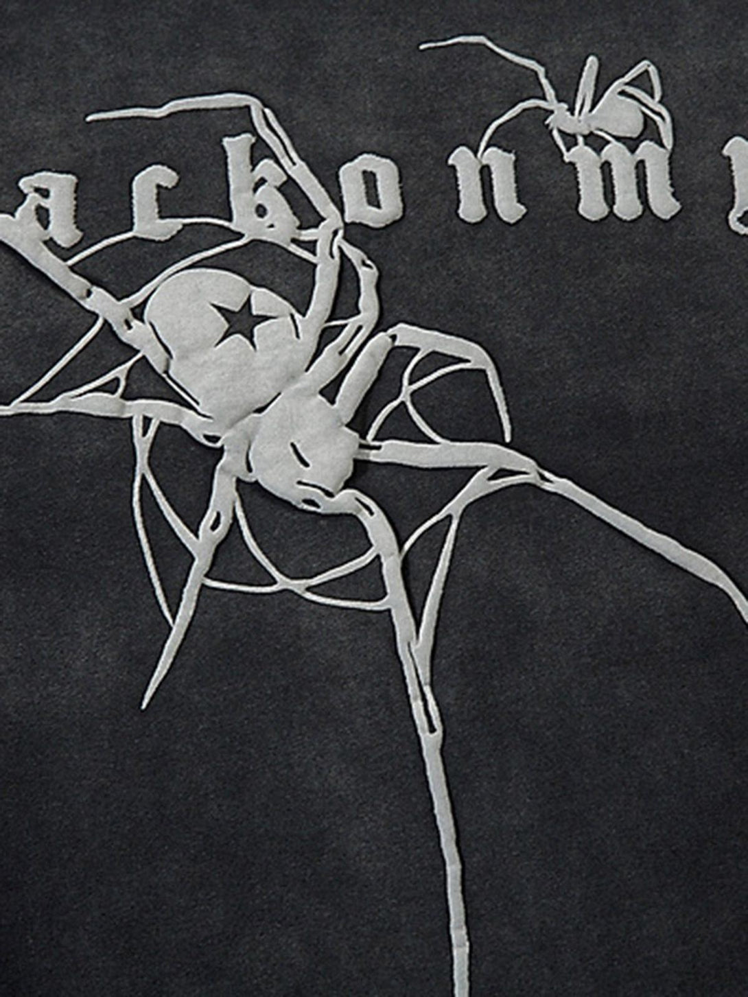 TALISHKO's spider pattern detail on a t-shirt, showcasing intricate design and texture.