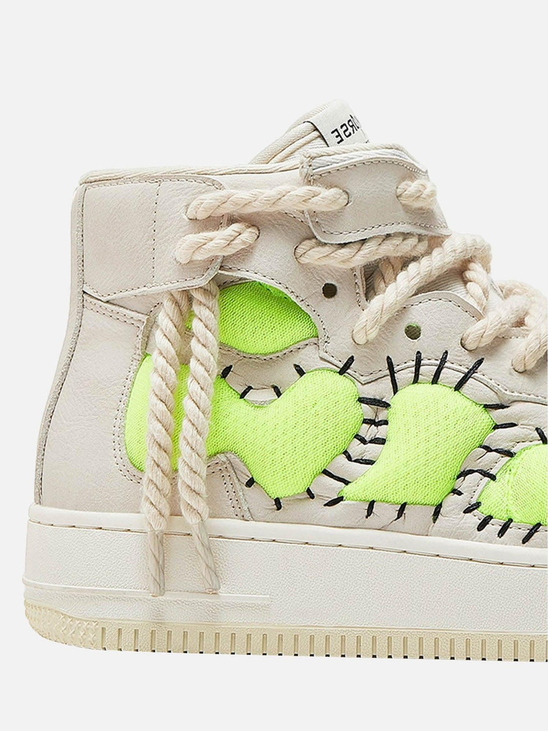 Intricate look at TALISHKO high-top sneakers with neon green accents and rope laces.