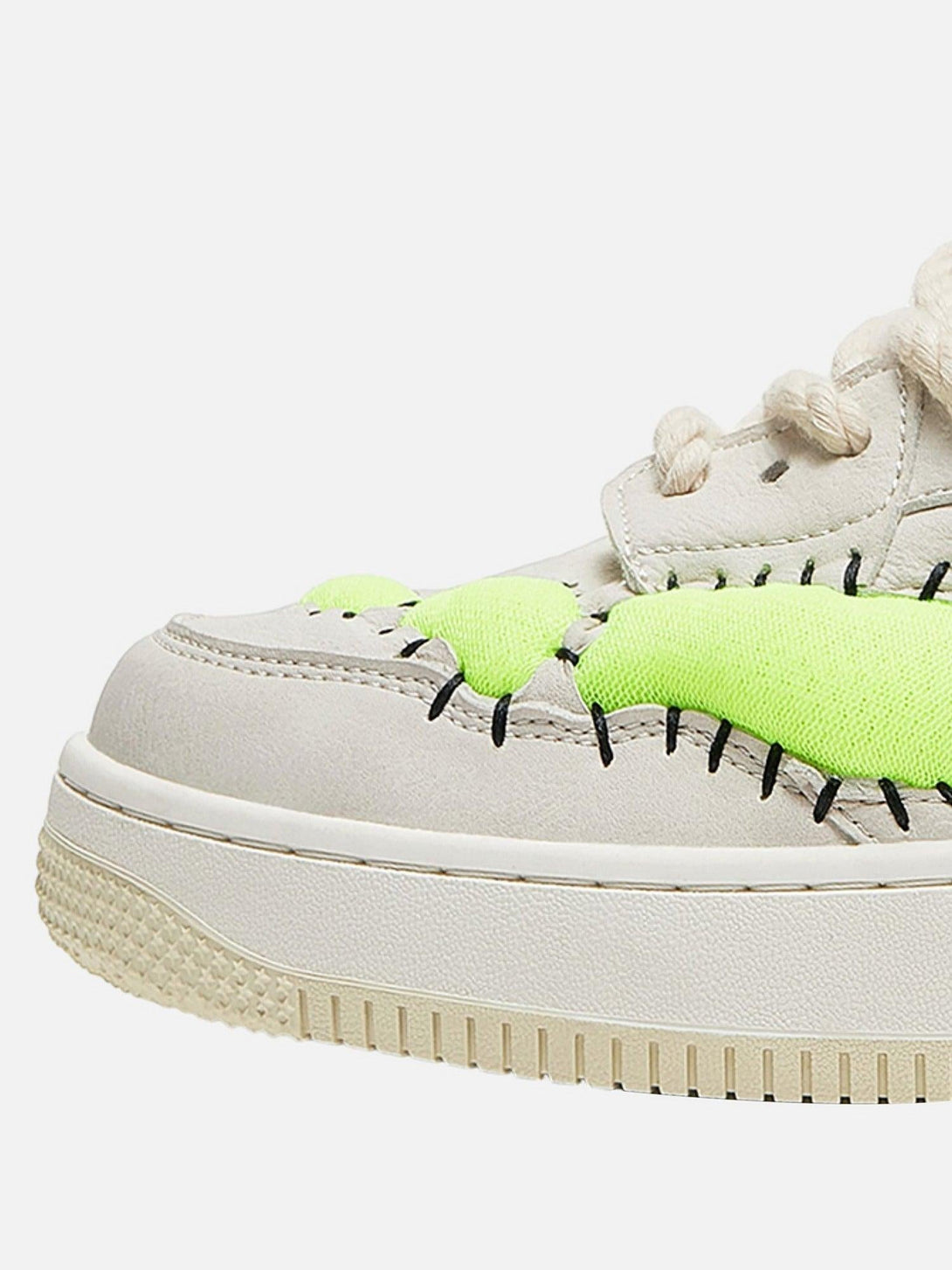 Close-up of TALISHKO sneakers, highlighting neon green details and bold stitching.