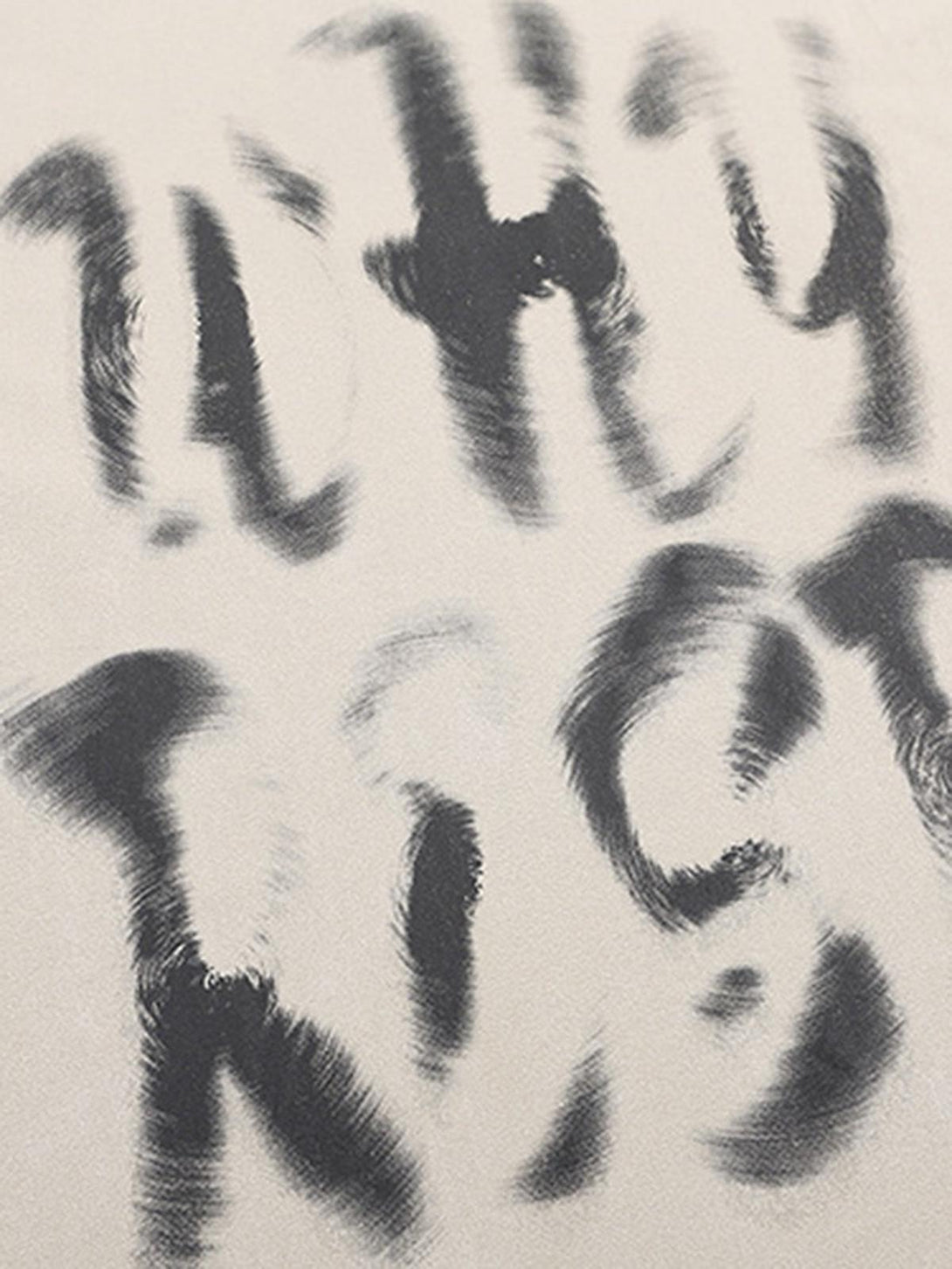 A tight crop highlighting abstract lettering on a beige vest by TALISHKO, perfect for unique style.