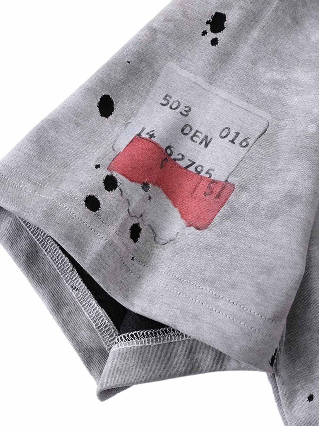 Intricate look at the ink splash design on TALISHKO's gray T-shirt, highlighting artistic detail.