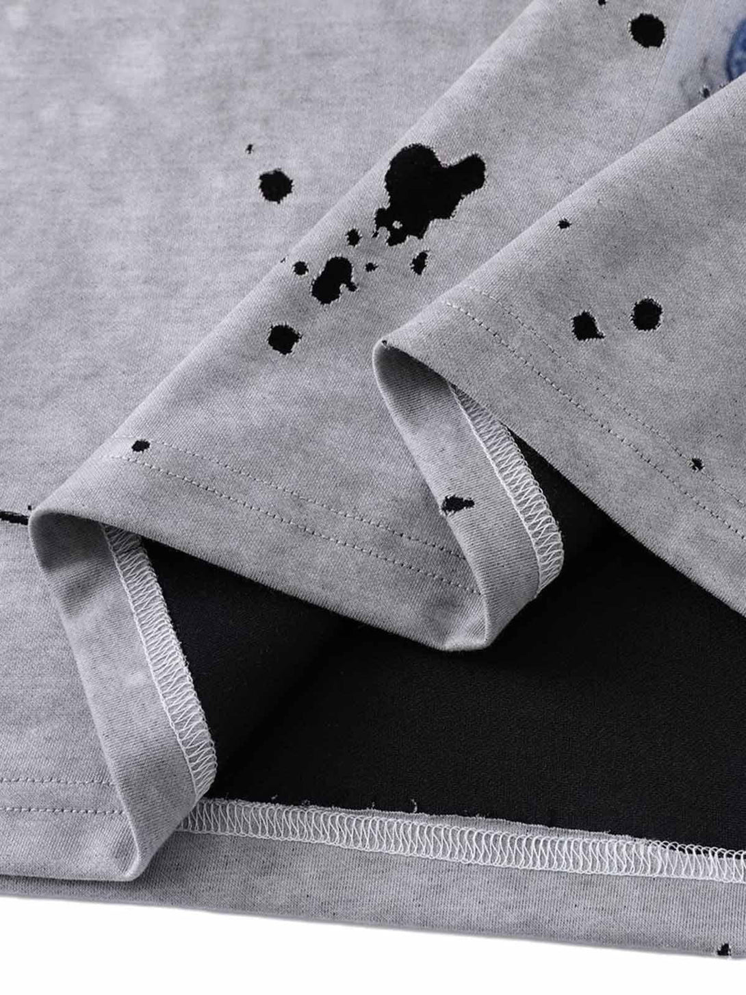 Detailed fabric and stitching on TALISHKO's retro ink splash T-shirt, emphasizing artistic design.