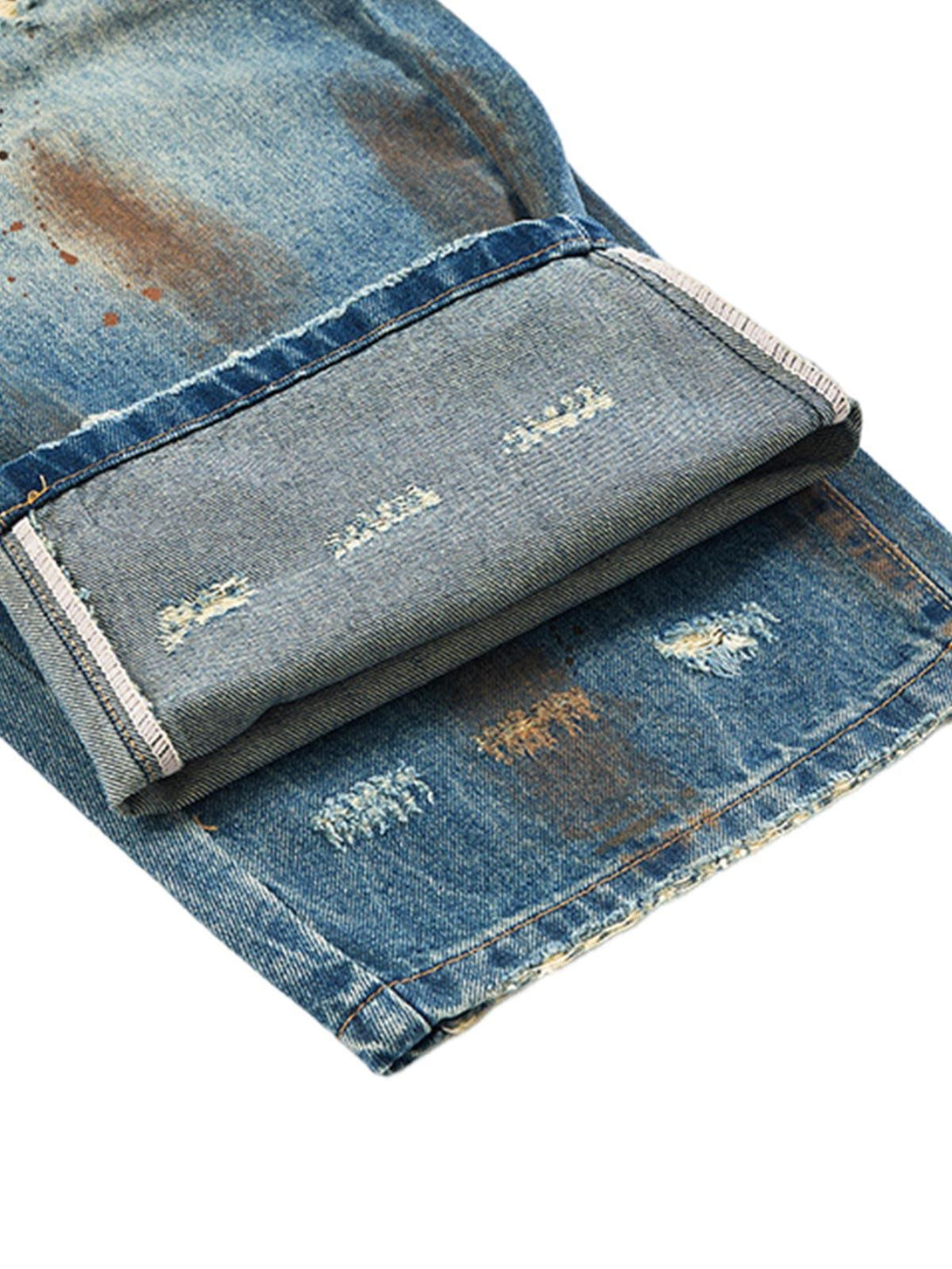 Intricate look at the cuff and distressed details of TALISHKO retro ink-splashed jeans.