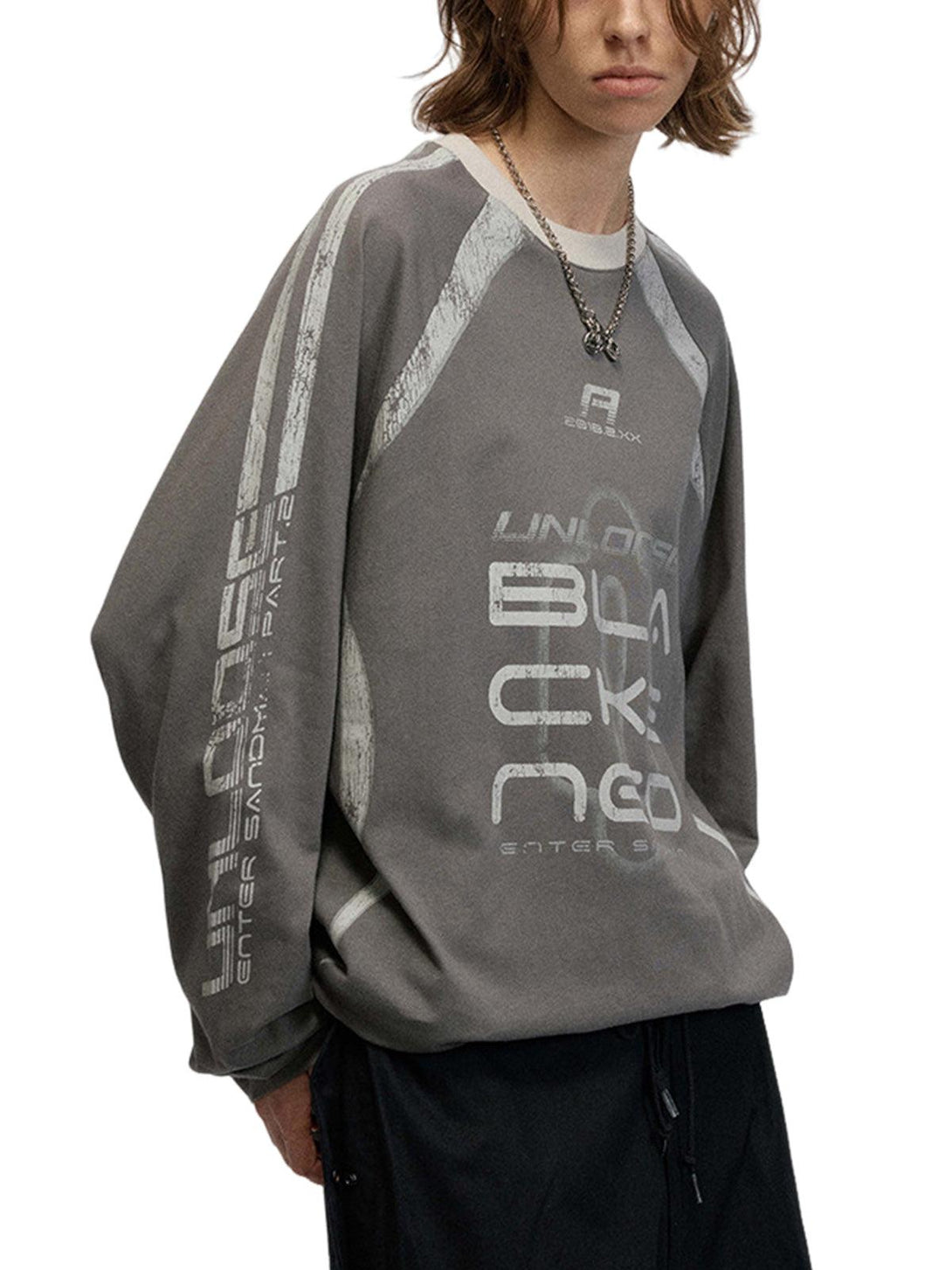 Model in oversized retro long-sleeve T-shirt by TALISHKO, featuring unique graphic design.