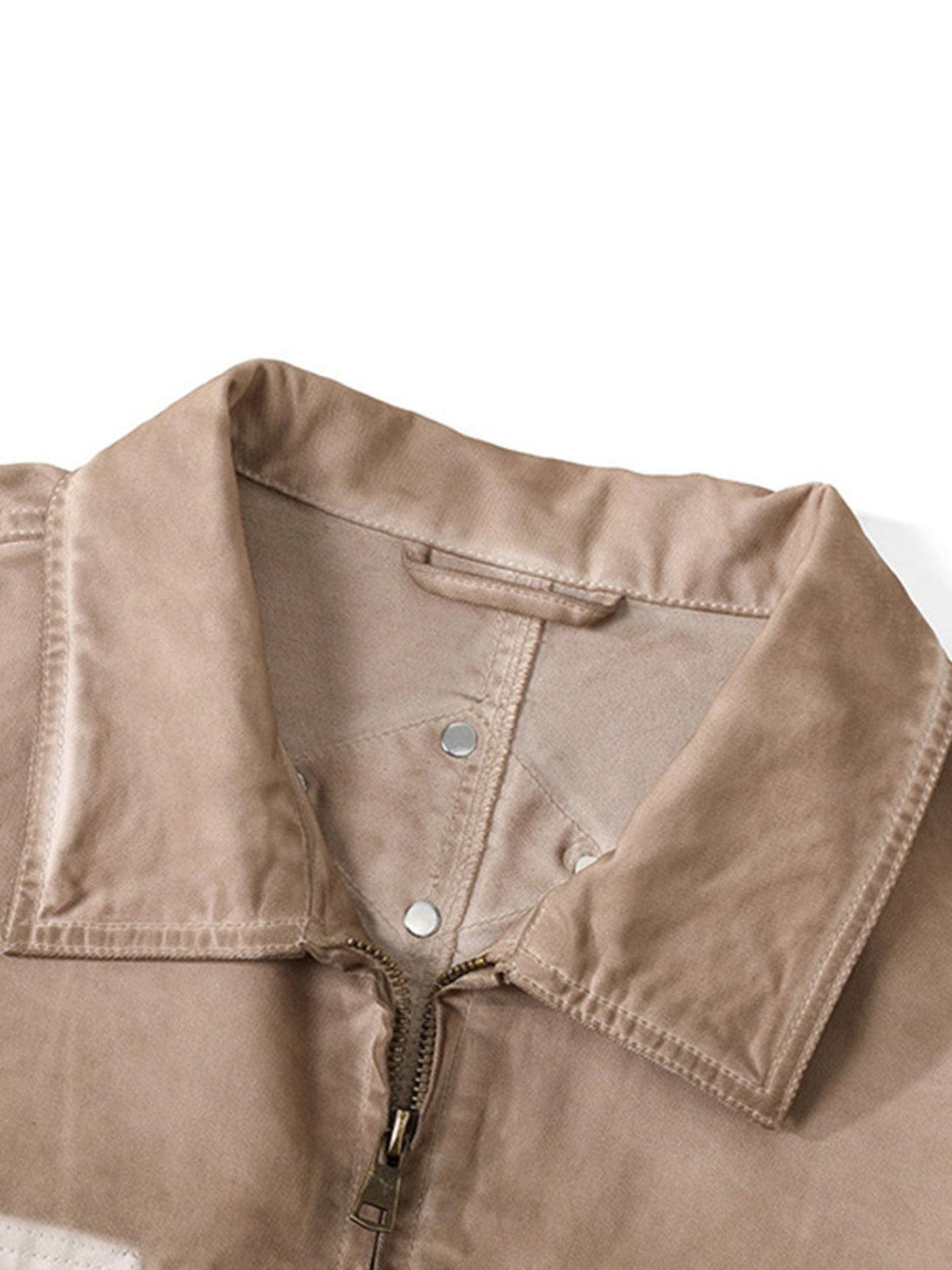 A close-up of the lapel and zipper detail on TALISHKO's retro work jacket.