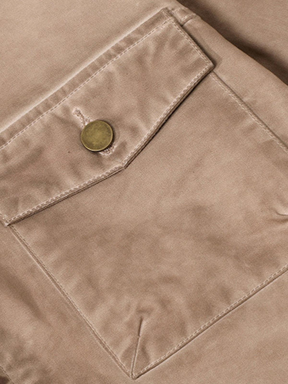 Zoomed-in view of TALISHKO's retro work jacket pocket, showcasing detailed stitching and button.