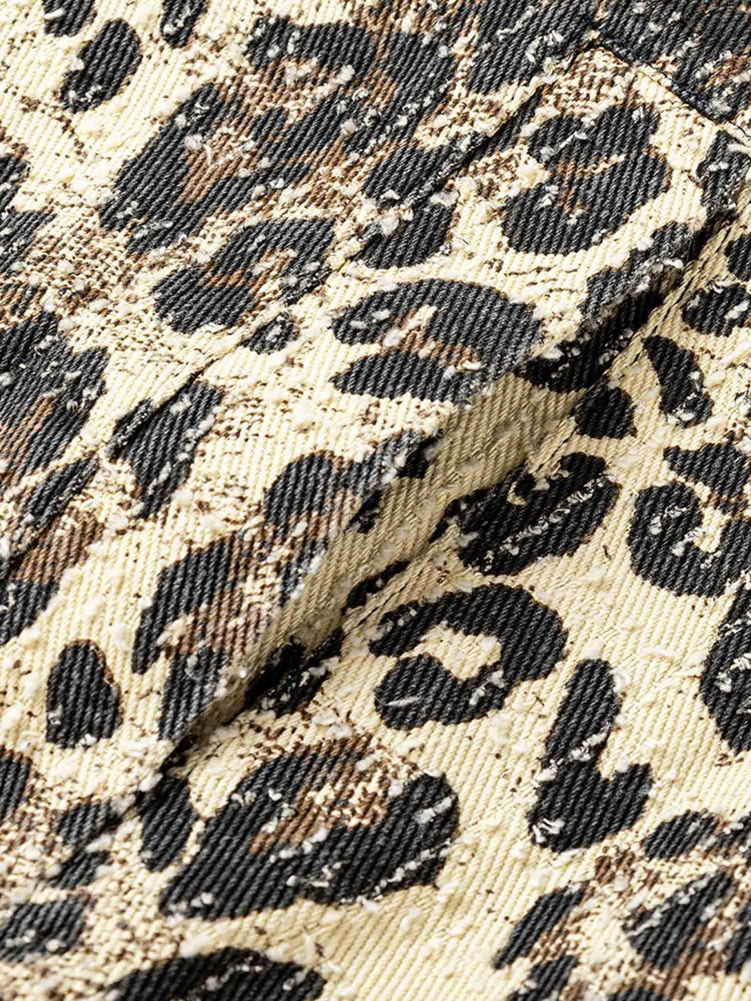 Intricate fabric detail of TALISHKO's retro leopard print denim jacket, showcasing bold patterns.