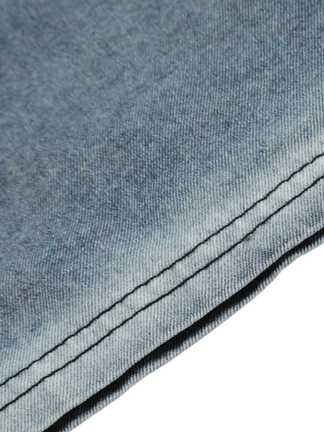 Intricate look at the stitching and texture of a TALISHKO denim T-shirt, emphasizing craftsmanship.