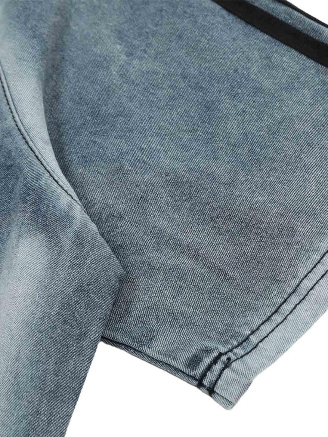 A tight crop highlighting the sleeve and stitching on TALISHKO's contrast denim T-shirt.