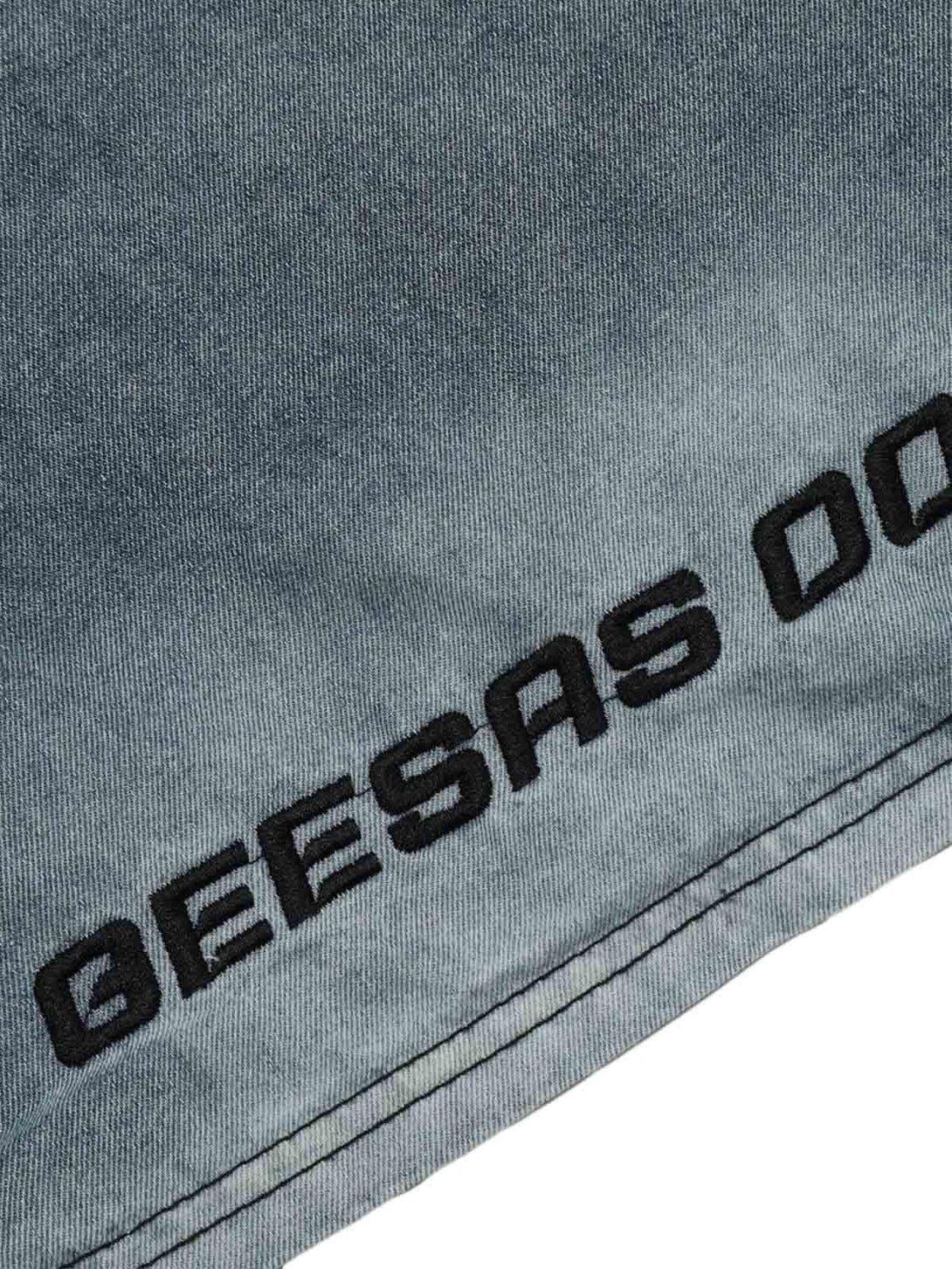 A detailed view of retro embroidery on a TALISHKO denim T-shirt, showcasing intricate stitching.