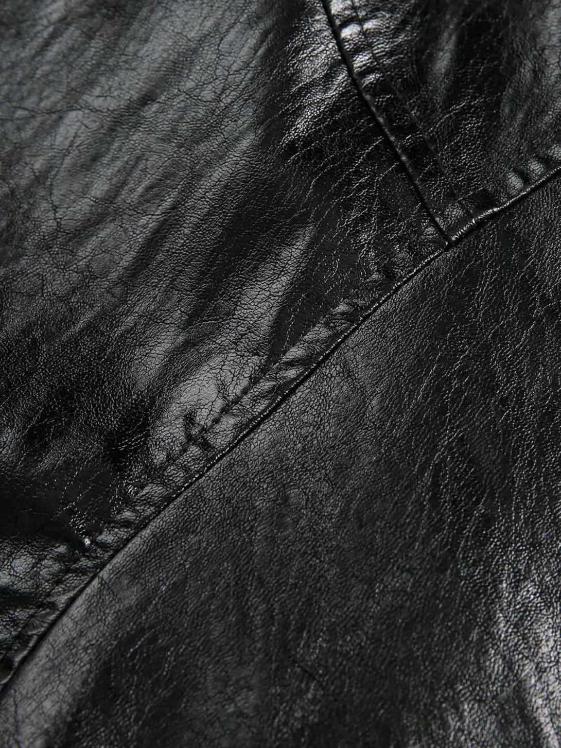 A tight crop highlighting the shiny texture and stitching of TALISHKO's retro motorcycle jacket.