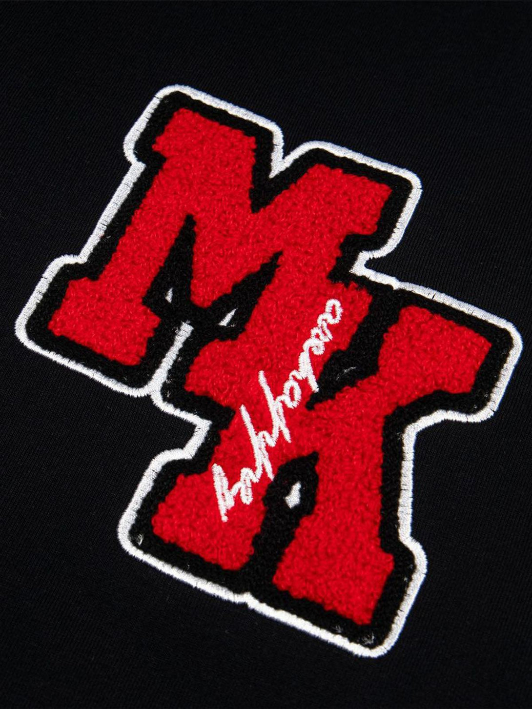 A close-up of TALISHKO T-shirt embroidery, highlighting bold red retro motorcycle patch.