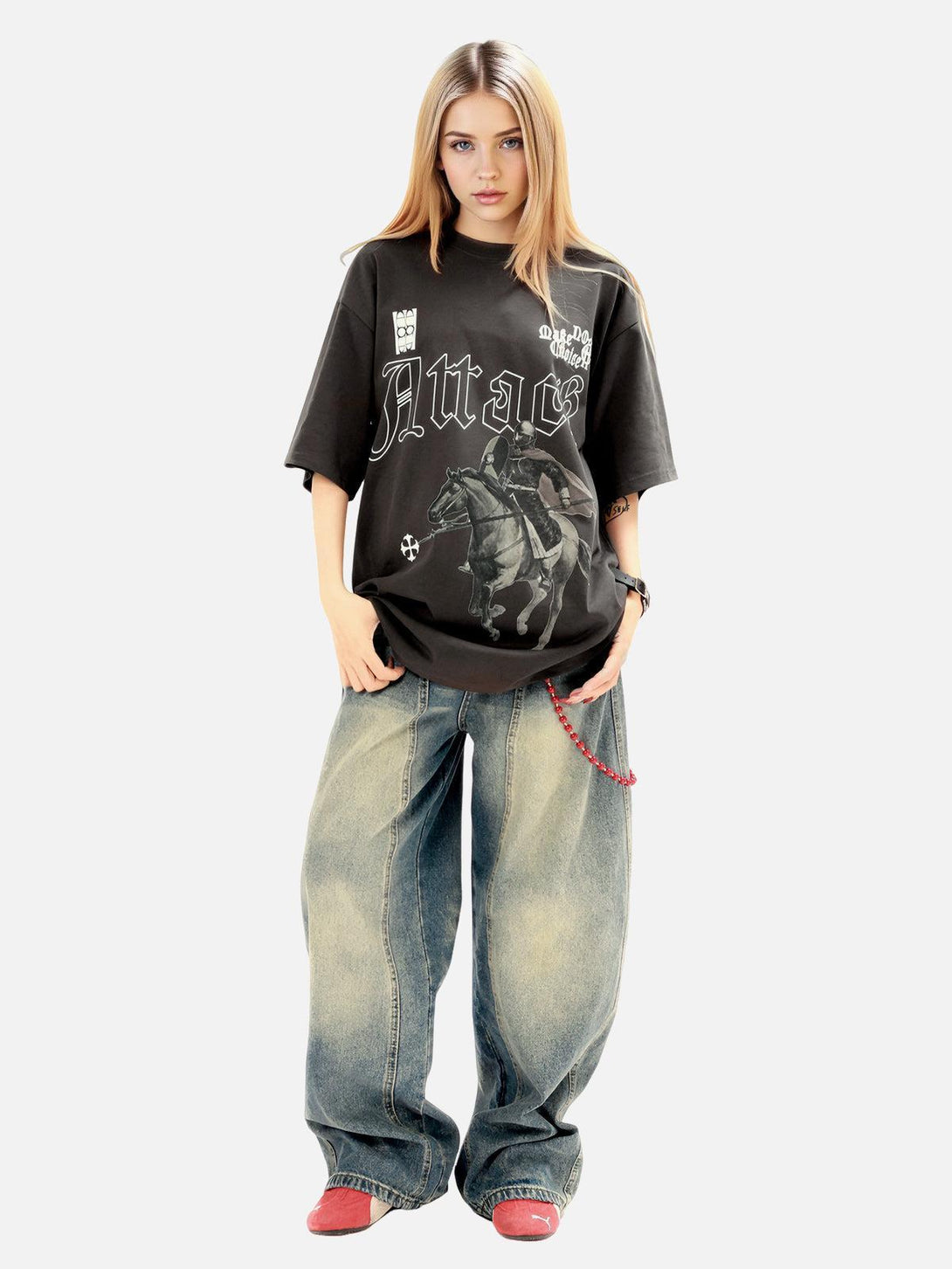 Model in oversized TALISHKO T-shirt with retro knight print, paired with wide-leg jeans.