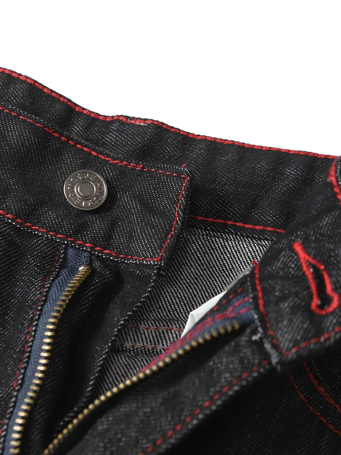 A close-up of TALISHKO retro patchwork jeans, highlighting red stitching and zipper detail.