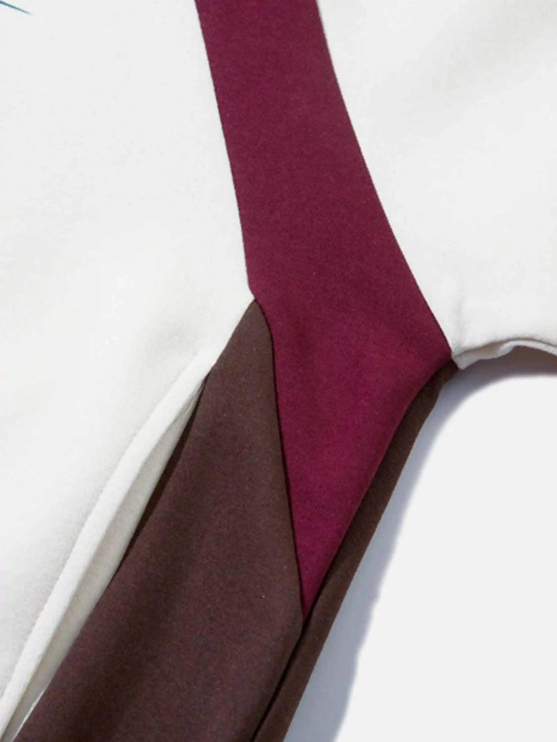 A close-up of the TALISHKO hoodie, showcasing retro patchwork details and fabric texture.