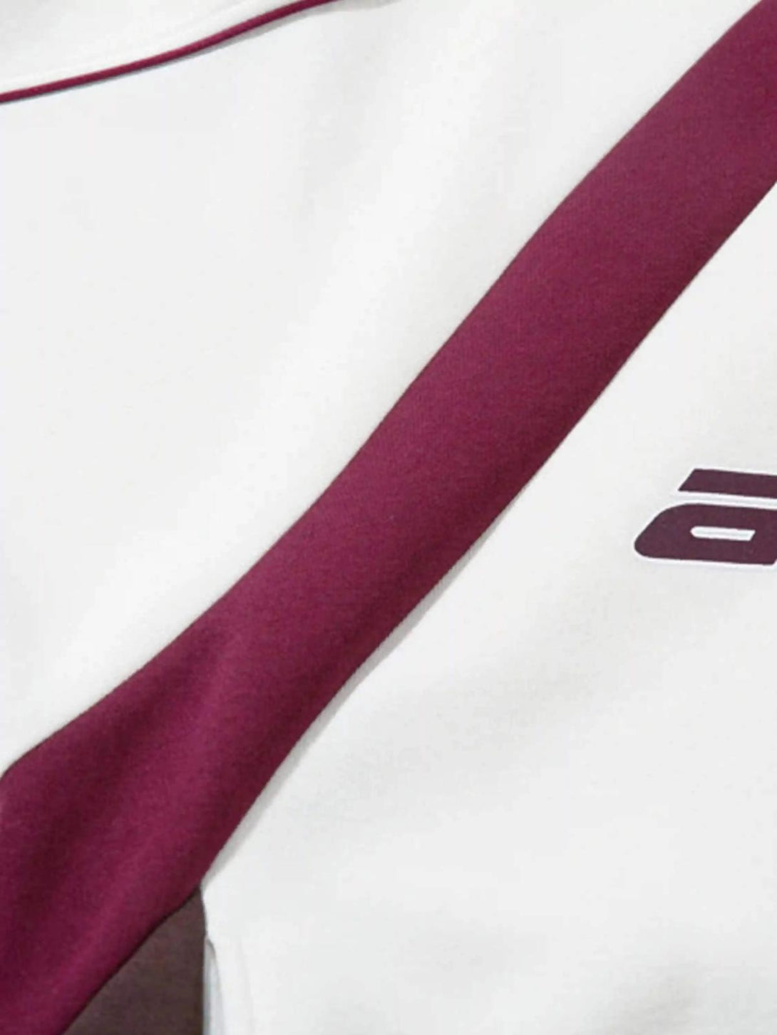 A detailed view of the TALISHKO hoodie, highlighting maroon patchwork and fabric texture.