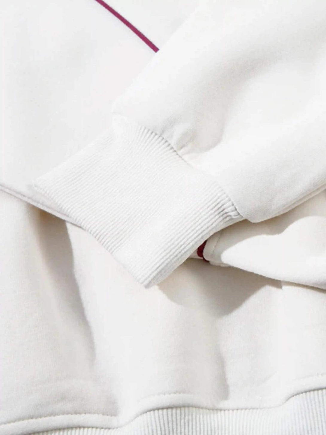 Focusing on the TALISHKO hoodie's cuff, highlighting fabric texture and subtle maroon detail.