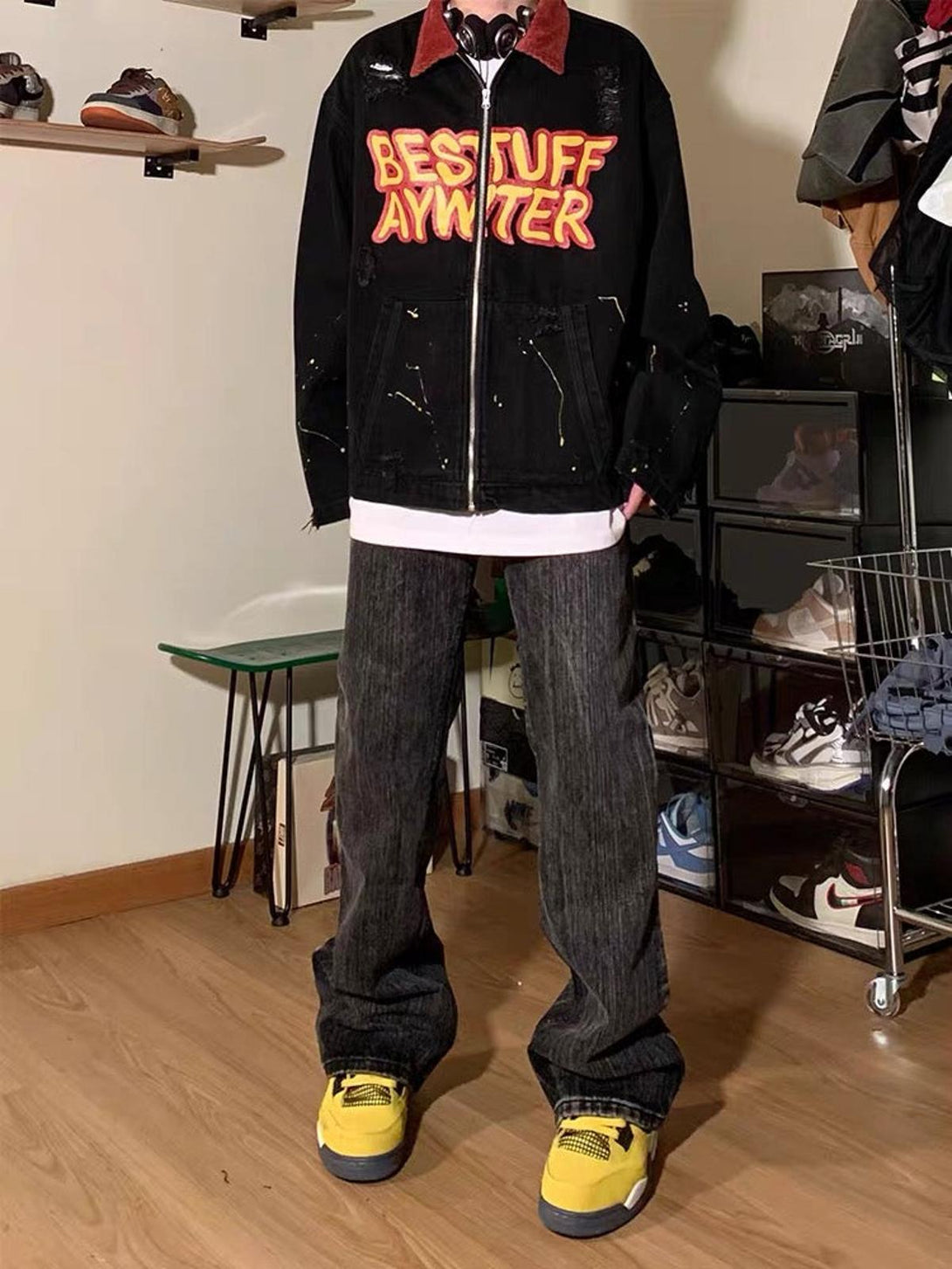 Model wearing TALISHKO's retro patchwork denim jacket with vibrant lettering and yellow sneakers.