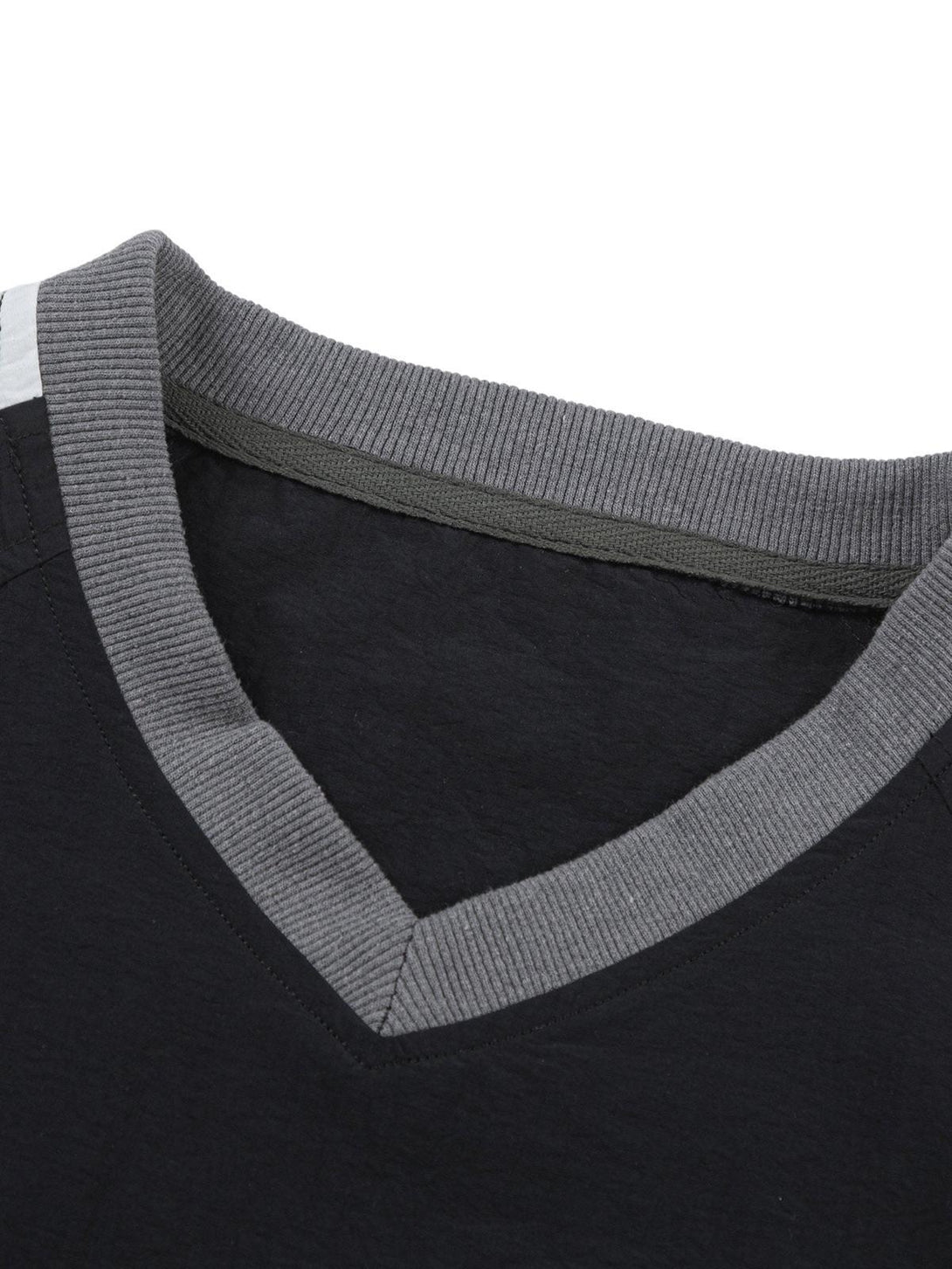 A detailed view of the neckline on a TALISHKO retro patchwork long-sleeved T-shirt.