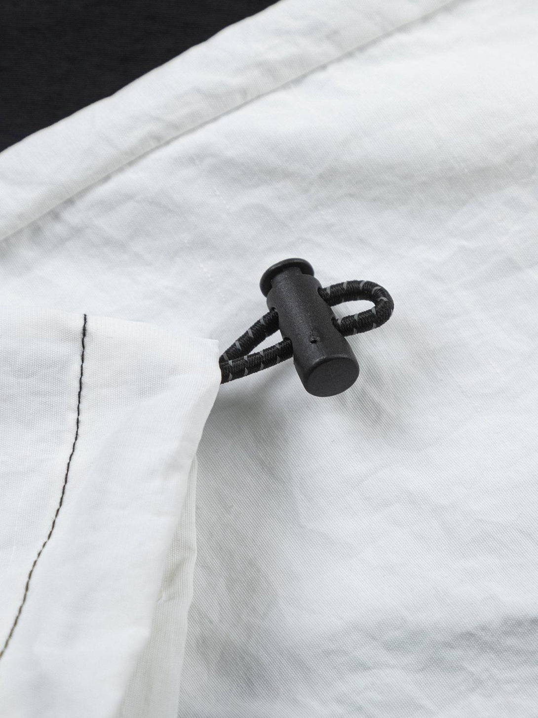 Focusing on the drawstring detail of a TALISHKO retro patchwork long-sleeved T-shirt.