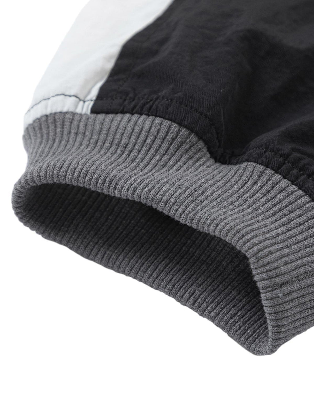 Detailed fabric and stitching on a TALISHKO retro patchwork long-sleeved T-shirt cuff.