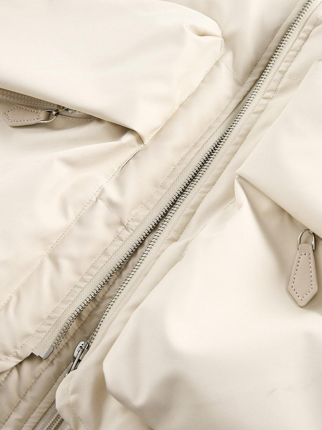 A detailed view of TALISHKO's puffer bomber jacket, highlighting the zipper and pocket design.