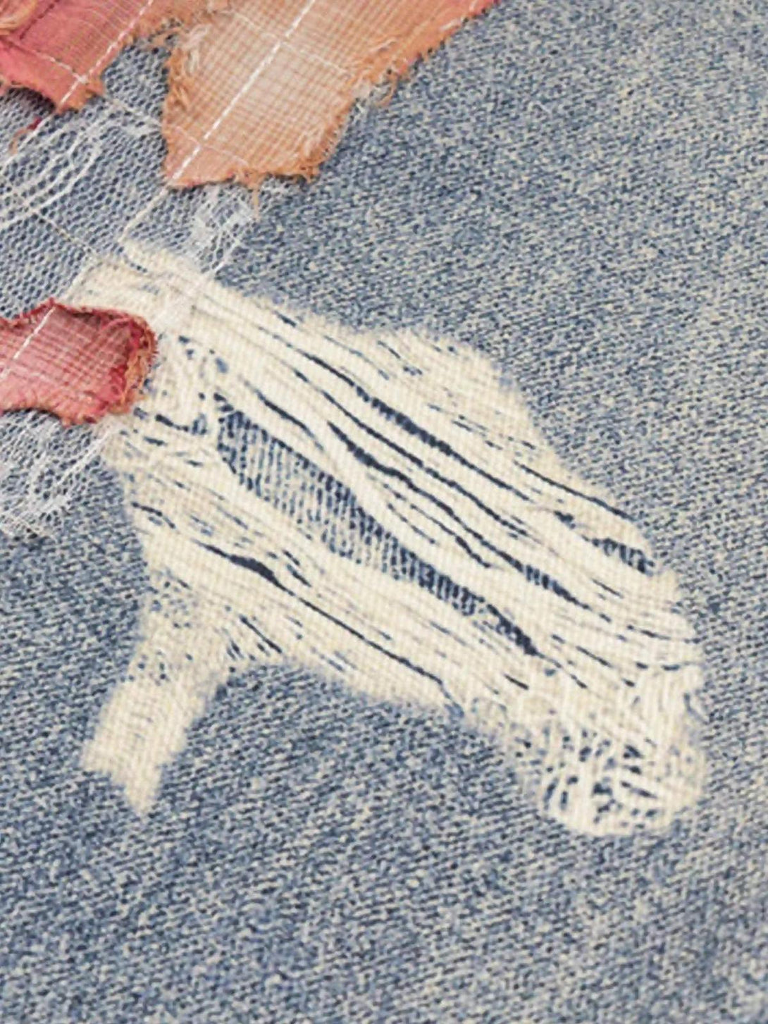 Intricate look at TALISHKO retro patchwork street jeans, highlighting unique distressed texture.