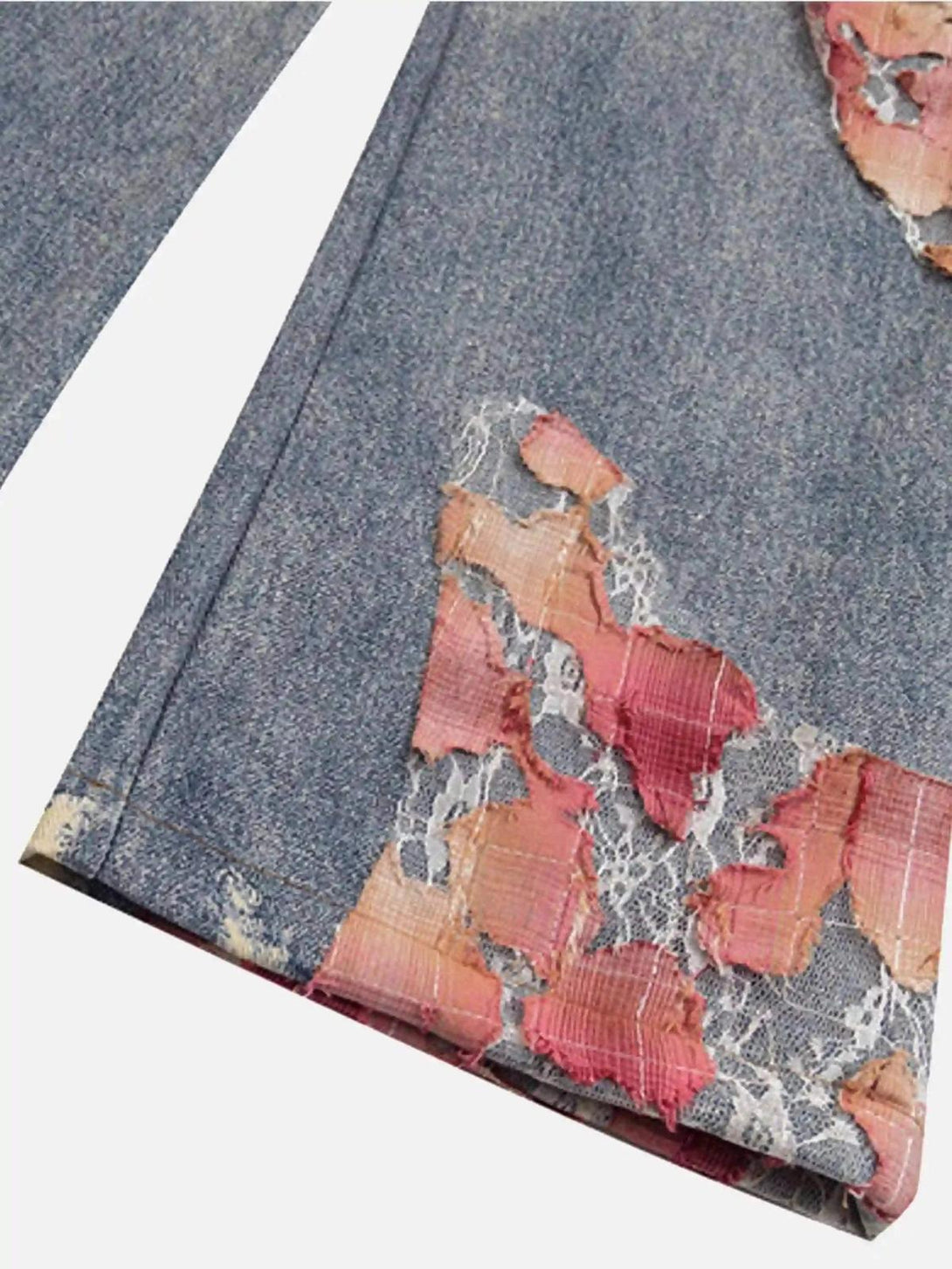 A detailed view of TALISHKO retro patchwork street jeans, highlighting colorful distressed fabric.