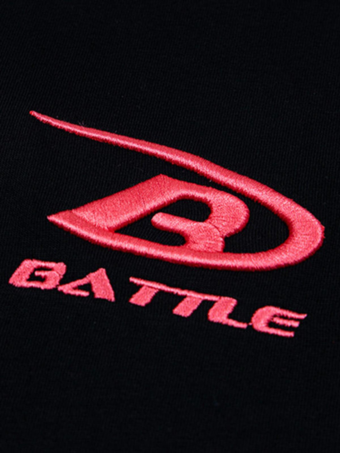 A tight crop highlighting the pink "BATTLE" logo on a black fabric by TALISHKO.