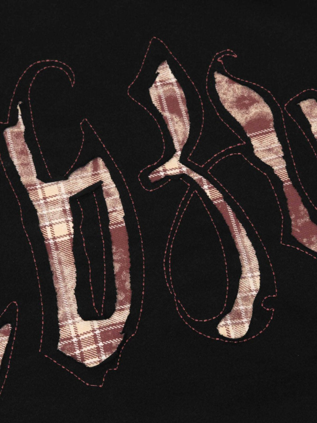 Intricate look at retro plaid letter embroidery on a TALISHKO T-shirt, perfect for casual style.