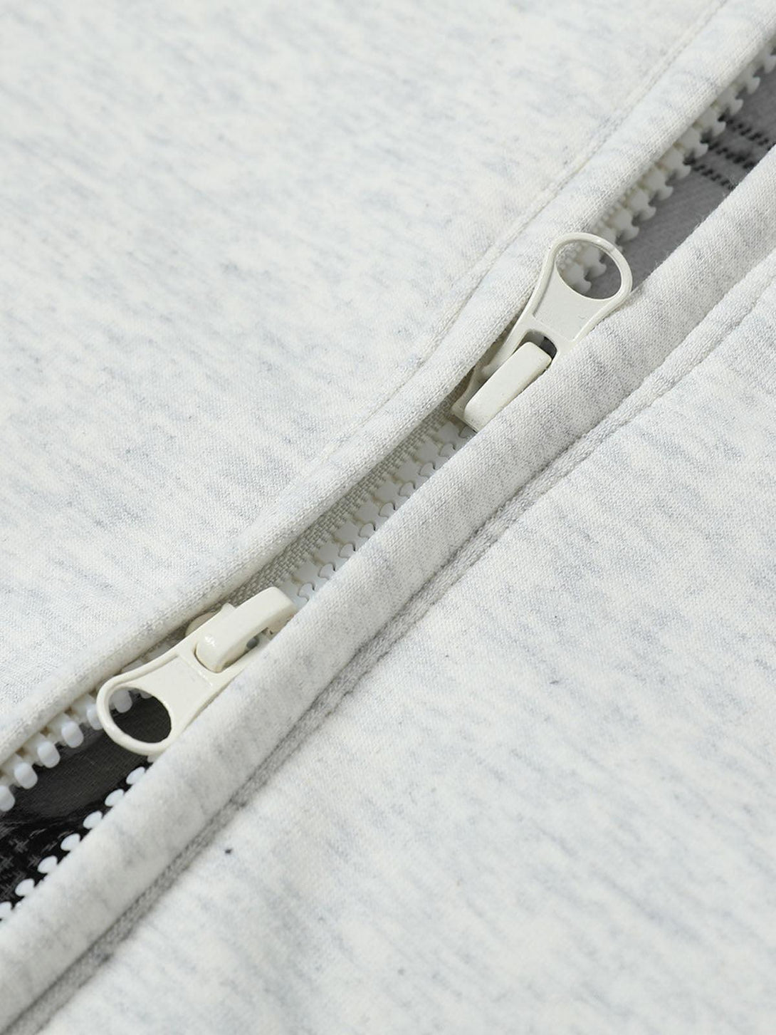 A close-up of TALISHKO's zip-up feature on the hooded sweatshirt, highlighting quality detail.