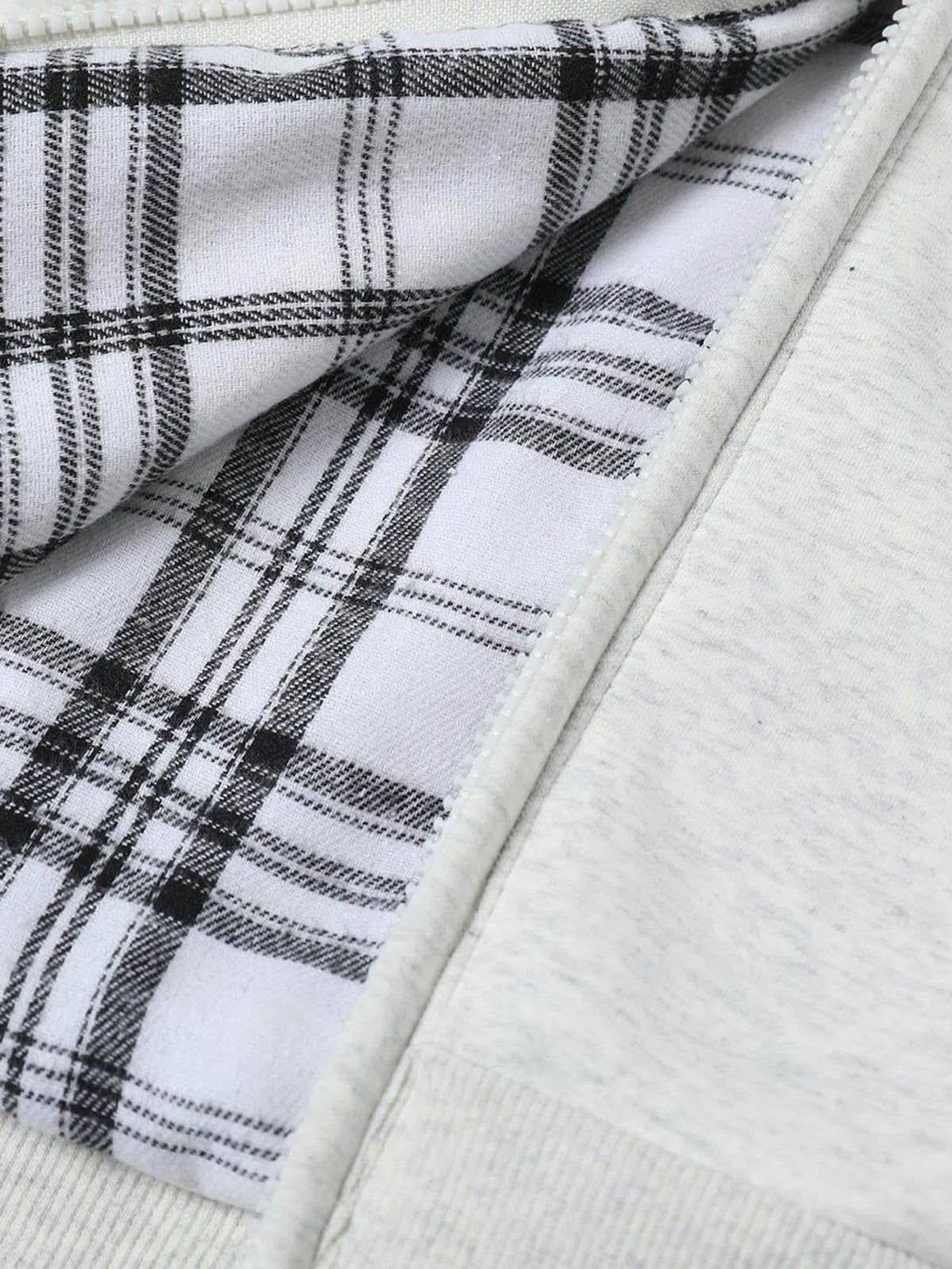 Focusing on the plaid lining detail of TALISHKO's zip-up hooded sweatshirt, showcasing texture.