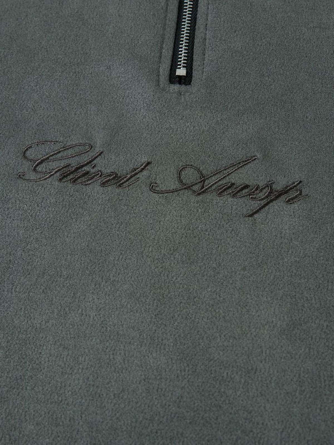 A close-up of TALISHKO's suede quarter zip T-shirt, highlighting intricate embroidery detail.