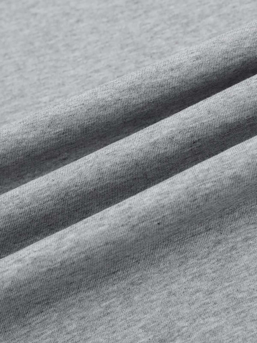 A detailed view of the soft gray fabric texture of a retro quilted T-shirt by TALISHKO.