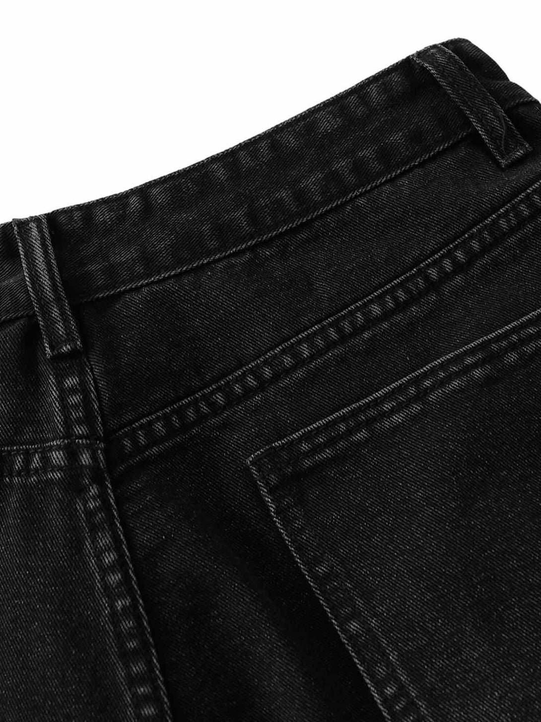 Intricate stitching and texture detail of TALISHKO's black denim shorts pocket.