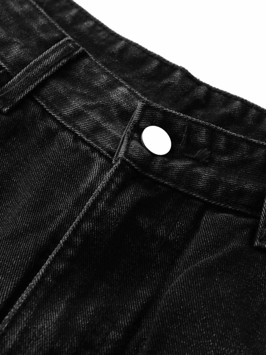 A close-up of TALISHKO's black denim shorts, highlighting a button detail and stitching.