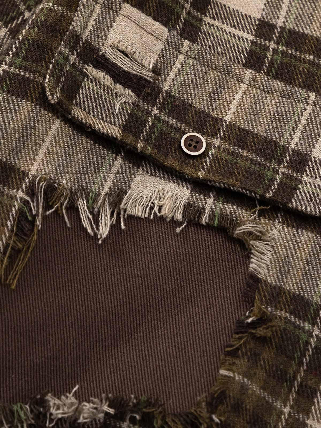 Intricate look at the ripped patchwork and plaid fabric on TALISHKO's shirt design.