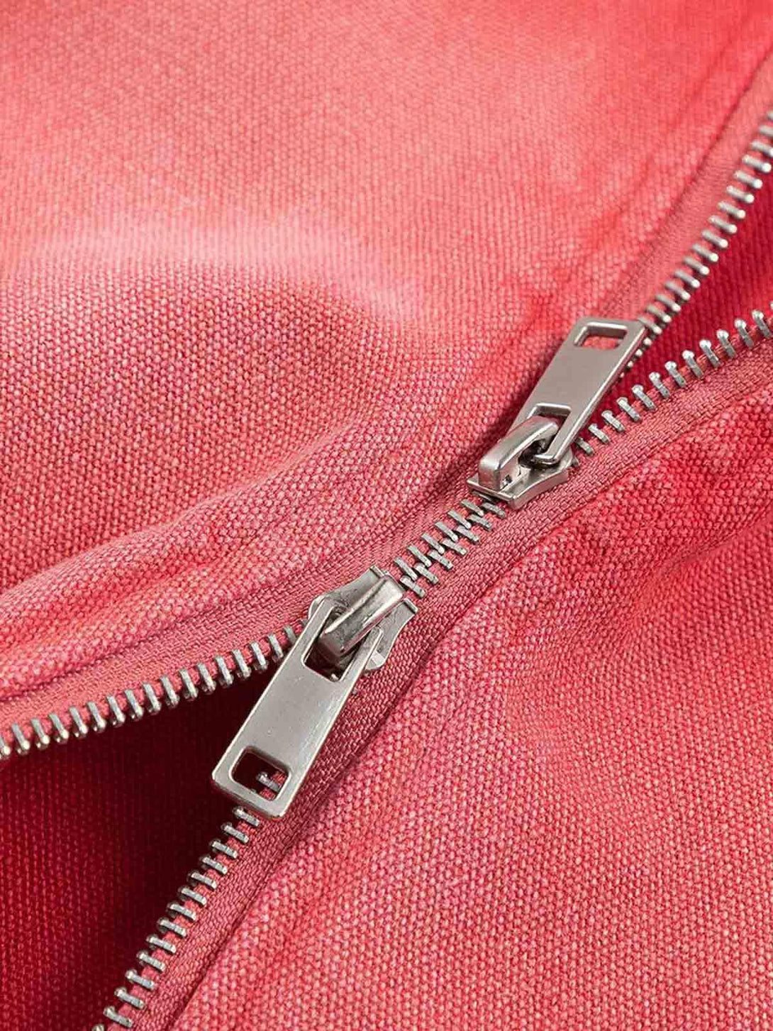 A close-up of TALISHKO's retro work jacket, highlighting the red fabric and silver zipper.