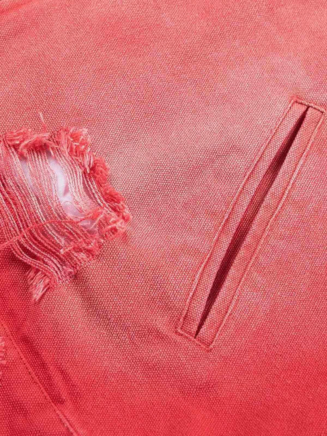 Zoomed-in texture of TALISHKO's retro work jacket, highlighting the red fabric and ripped detail.
