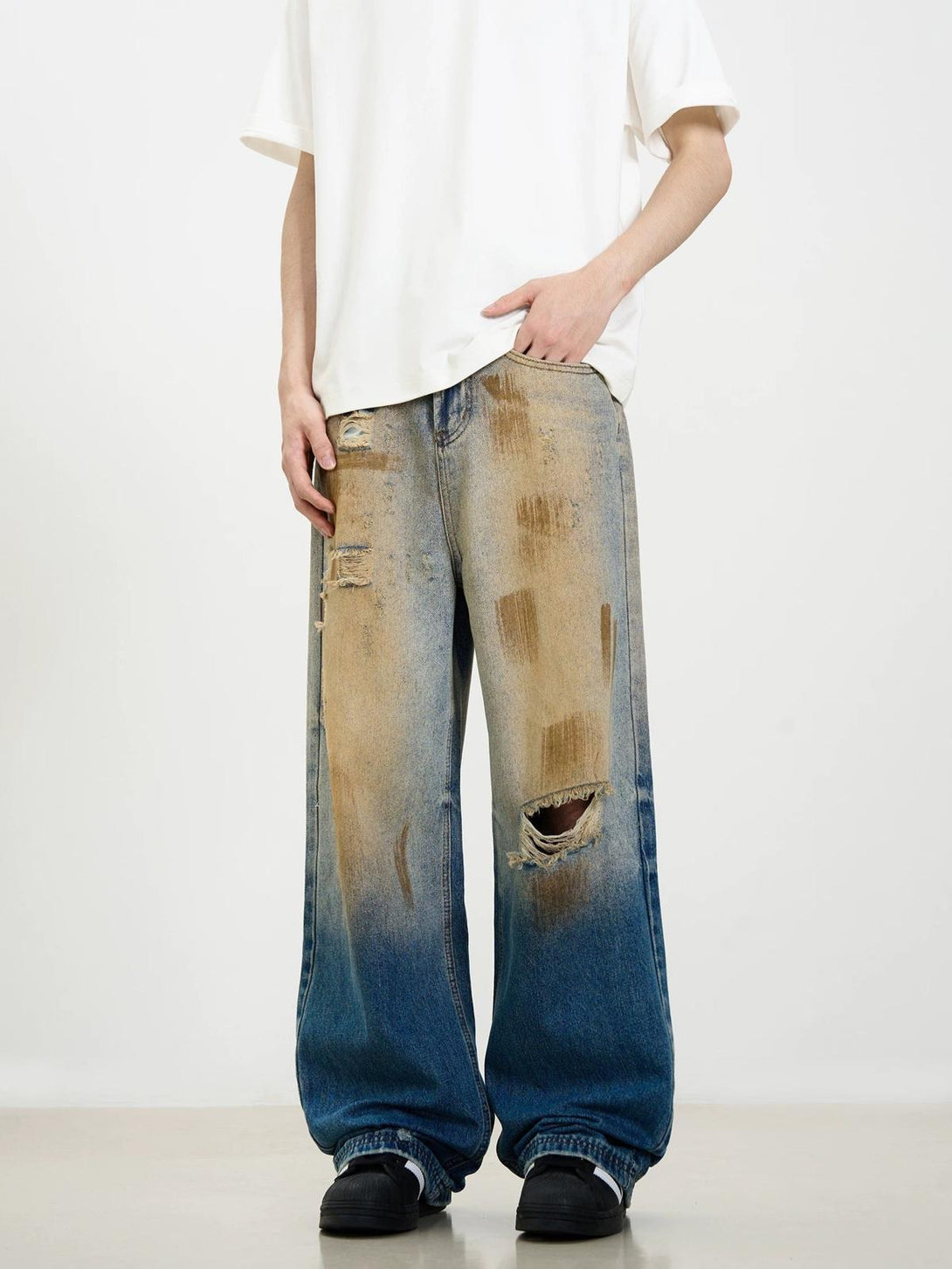 Model wearing TALISHKO's retro street-style jeans with distressed patina and wide-leg fit.