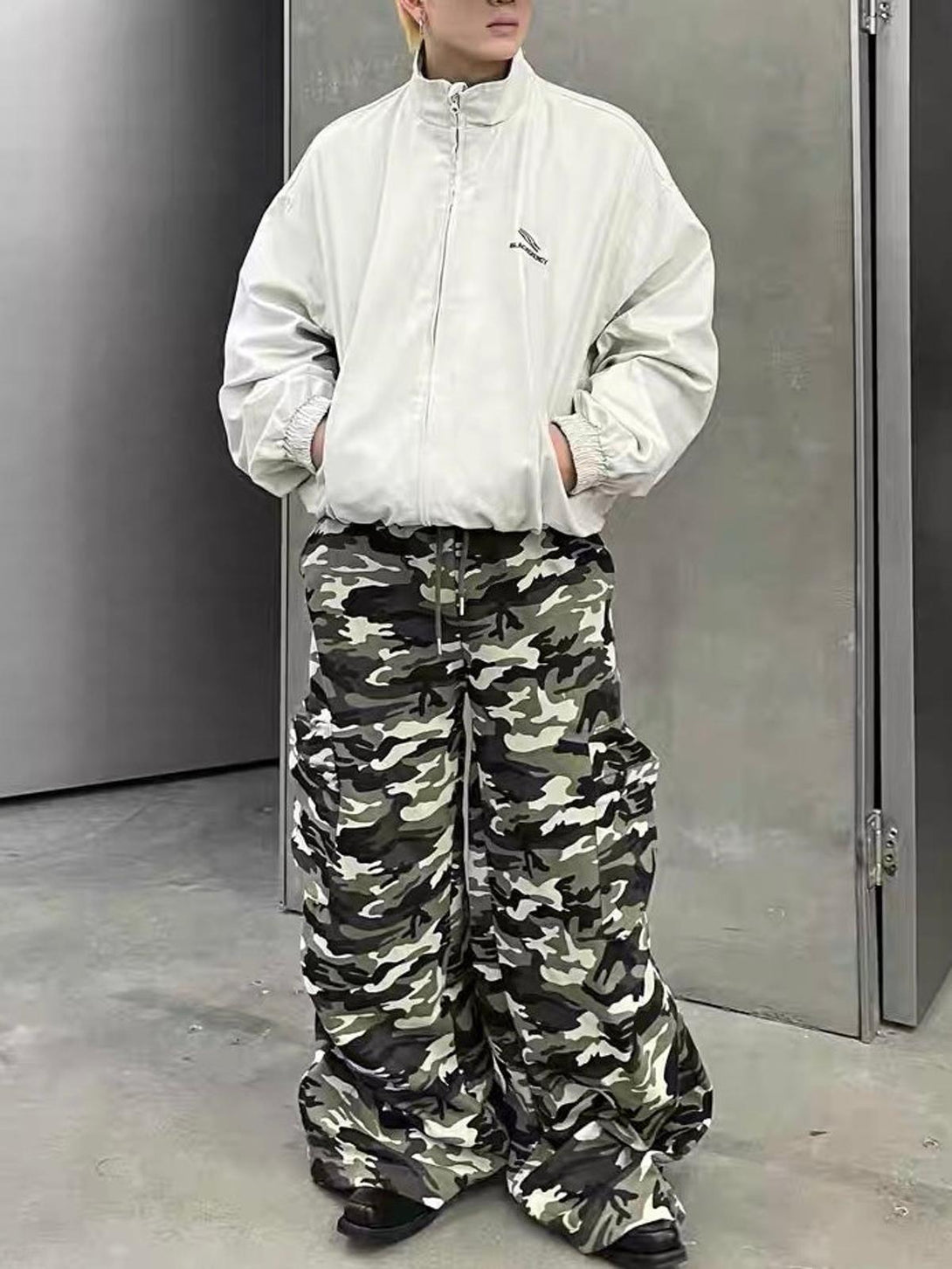 Model wearing a TALISHKO retro stand collar jacket with oversized camouflage cargo pants.