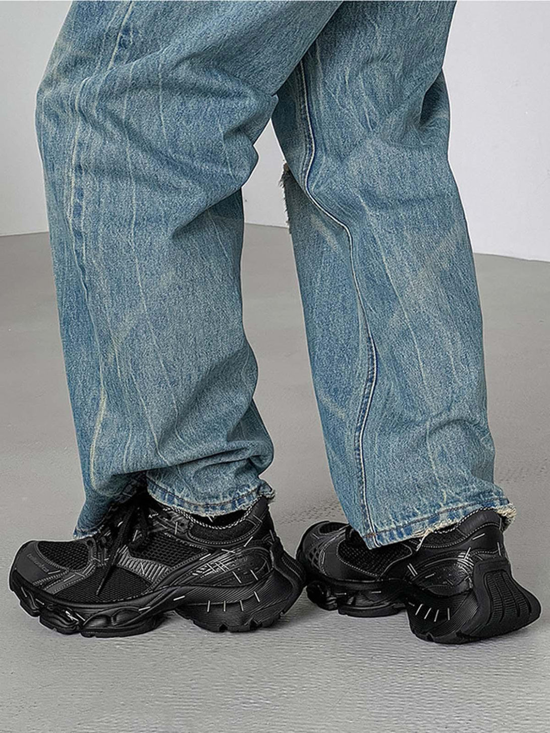 TALISHKO chunky sneakers in black paired with loose denim, showcasing a casual street style.