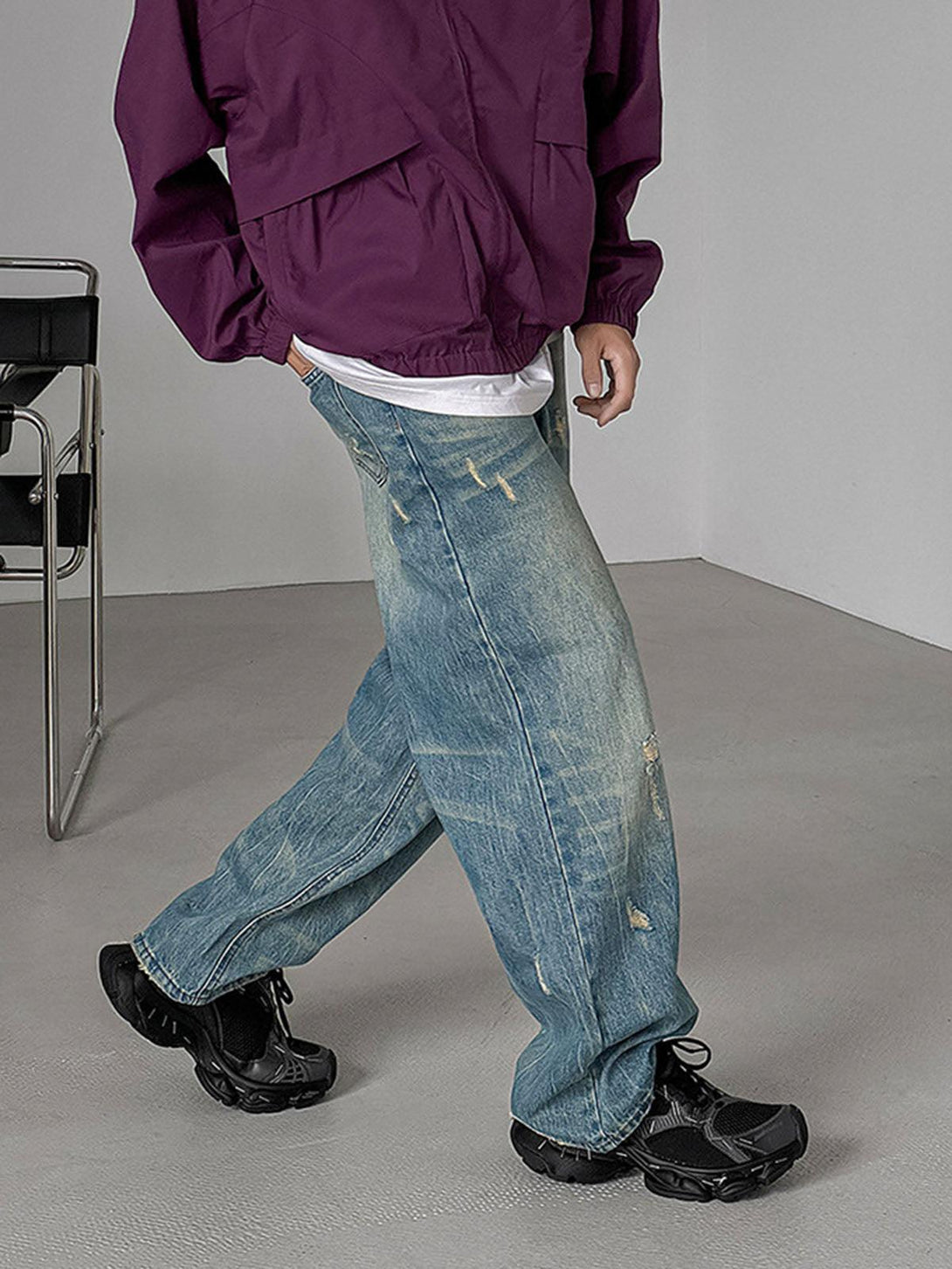 TALISHKO chunky sneakers in black paired with distressed jeans, highlighting a casual streetwear look.