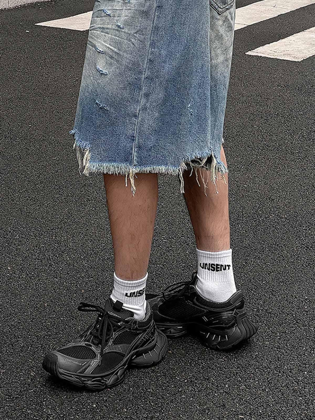 Distressed denim shorts paired with TALISHKO chunky sneakers for a streetwear vibe.